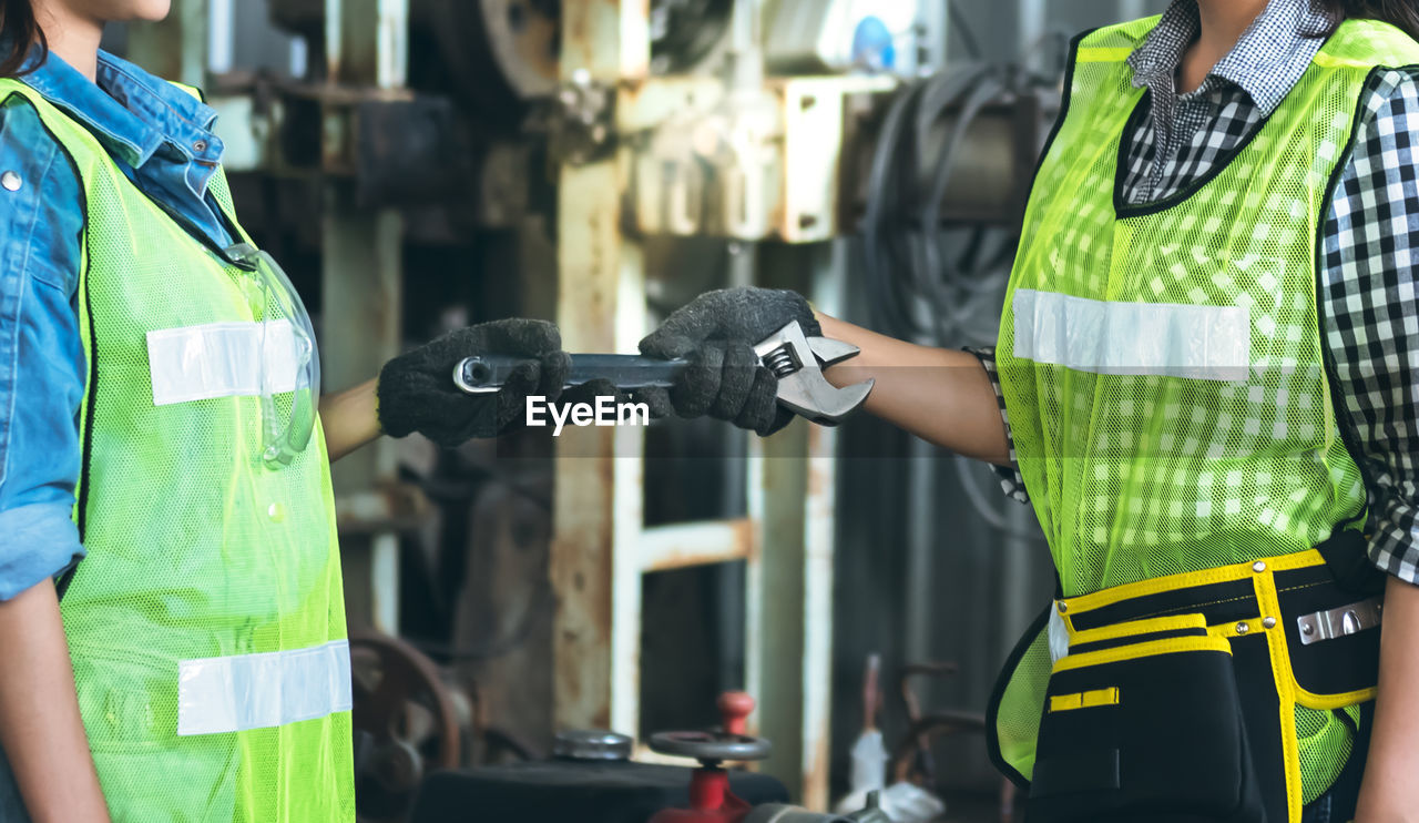 MIDSECTION OF MAN WORKING AT CAMERA