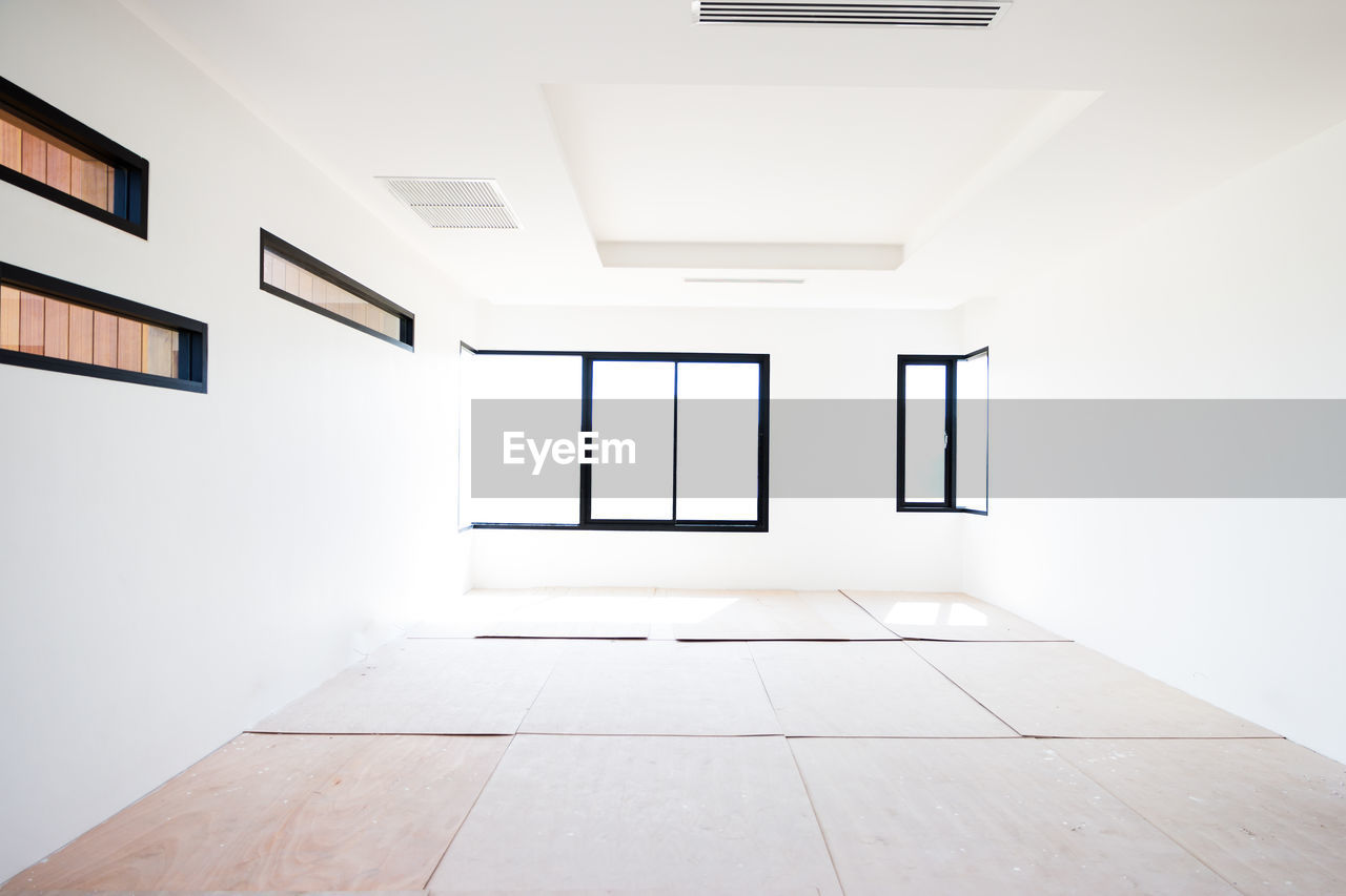 VIEW OF EMPTY CORRIDOR OF BUILDING WITH CEILING