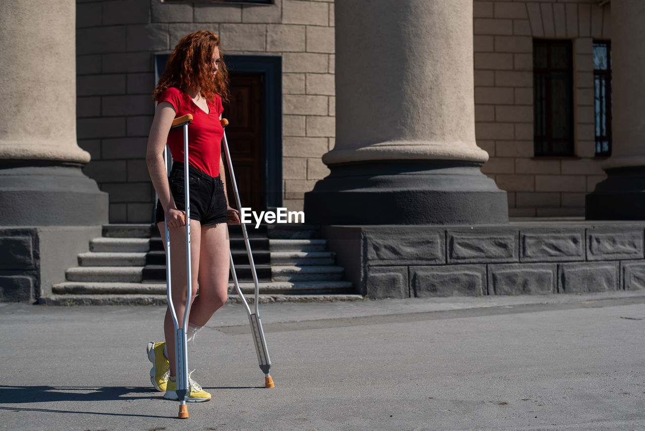 Rear view of woman with umbrella in city