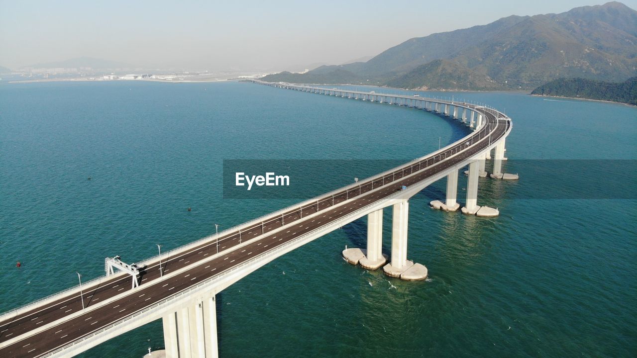 High angle view of bridge over sea against mountain