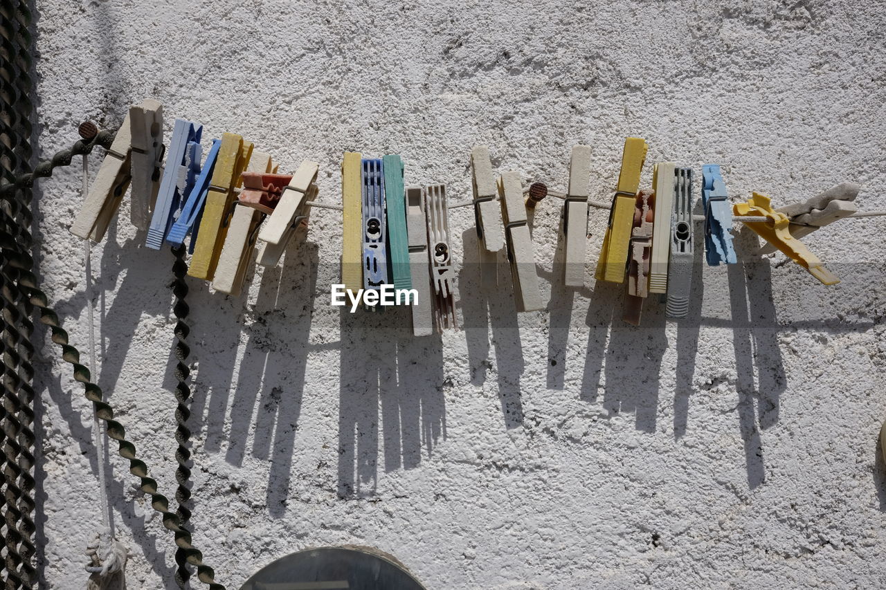 Clothespin hanging on string against wall