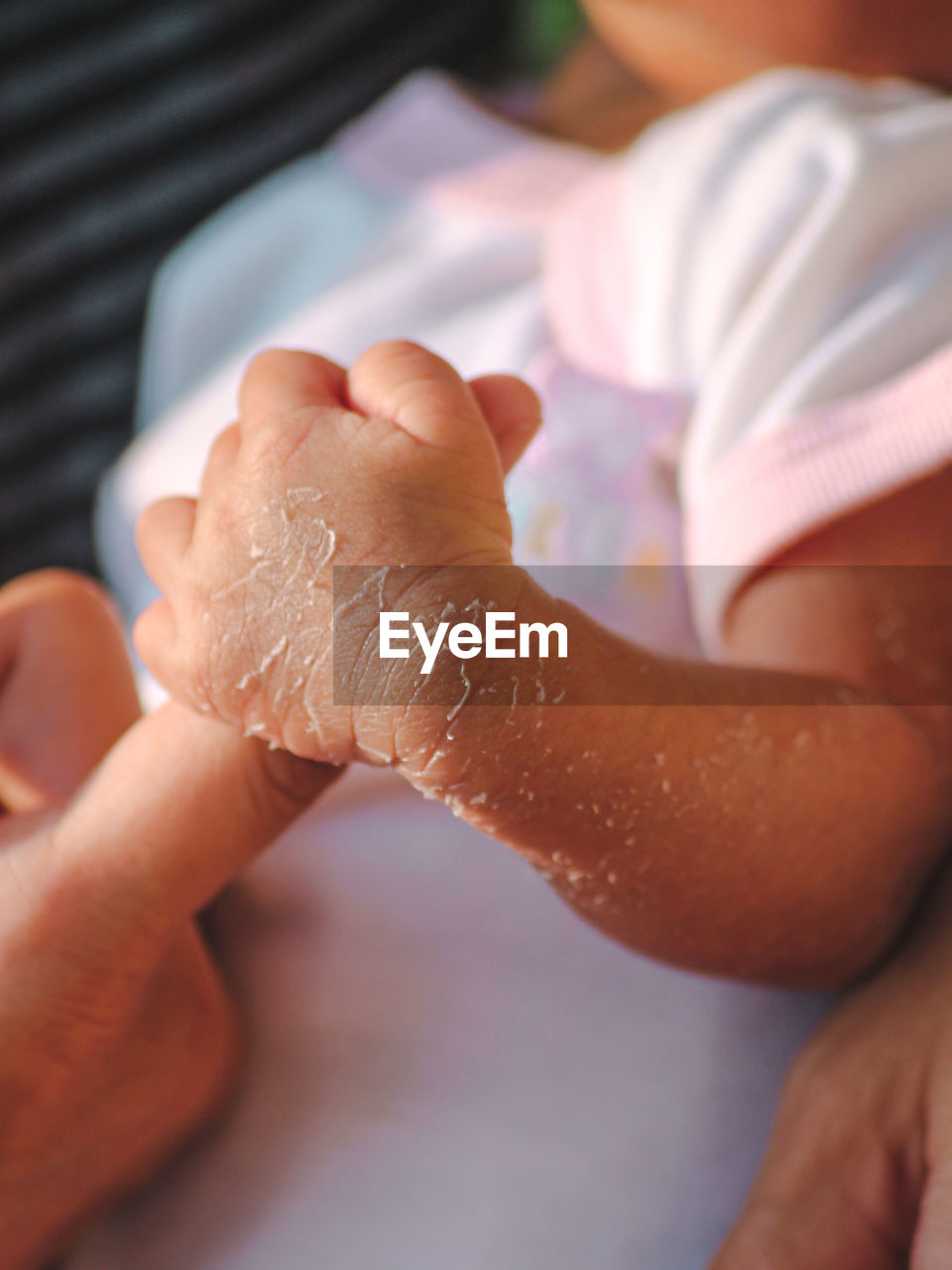 Close-up of baby holding person finger