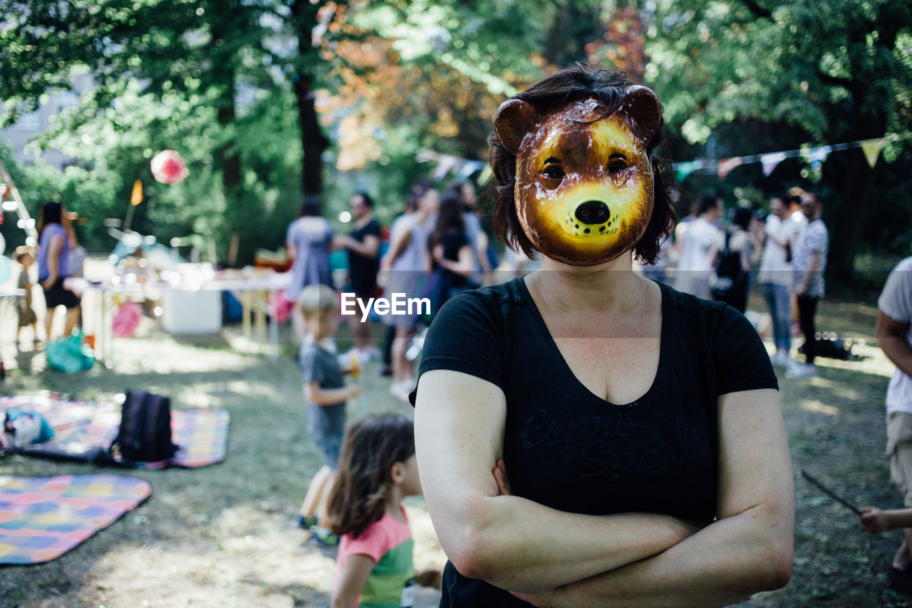 Portrait of woman wearing tiger mask in park