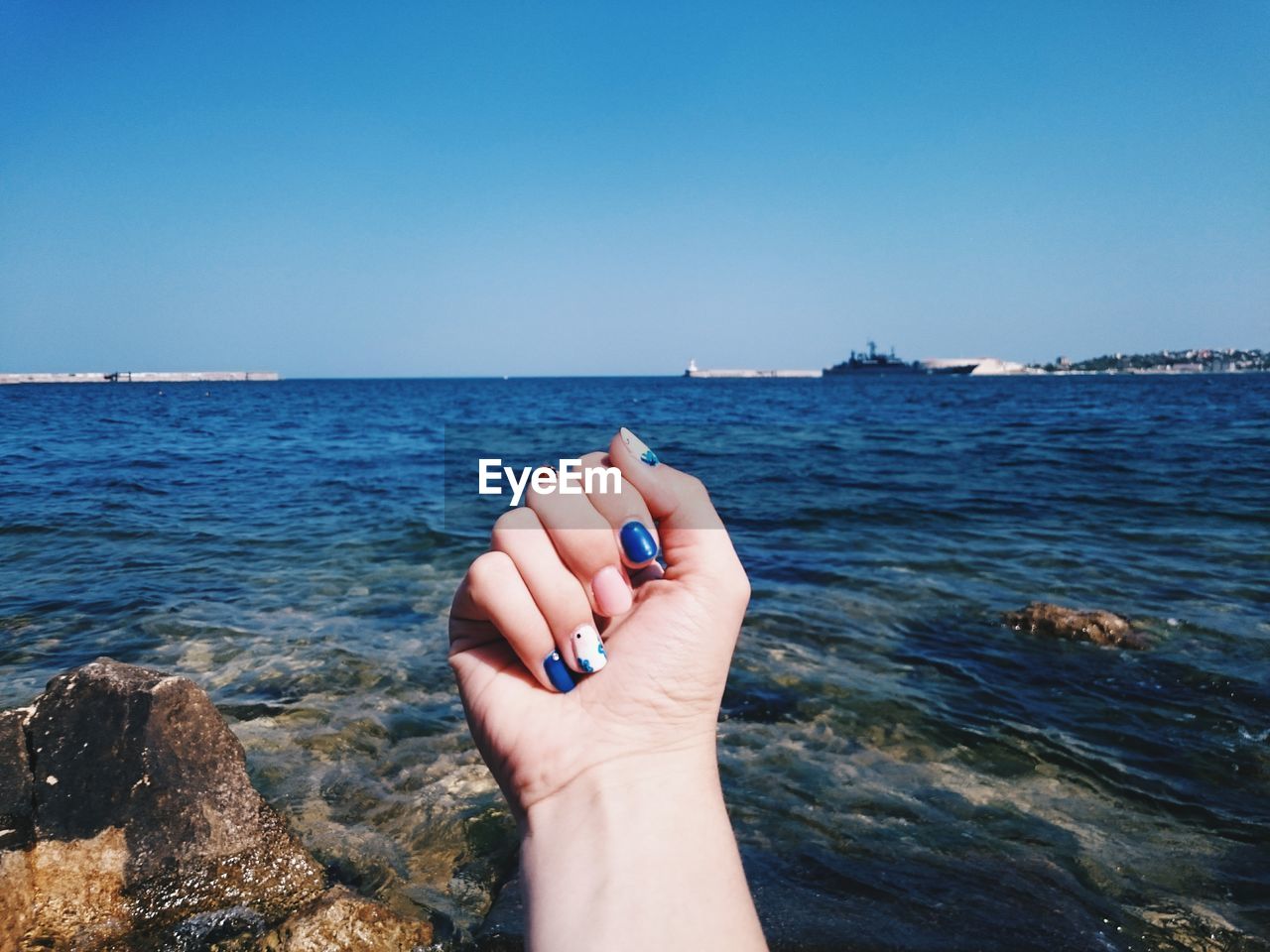 Human hand against sea
