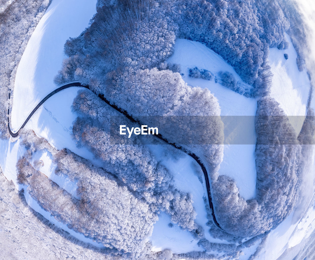 Aerial winter landscape. road leading through snowcapped winter forest. aerial view. 