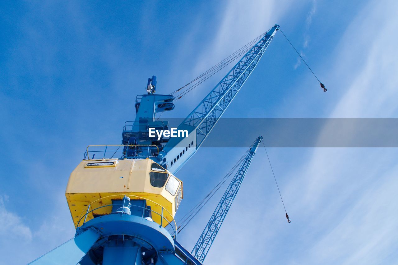 LOW ANGLE VIEW OF CRANES AGAINST SKY