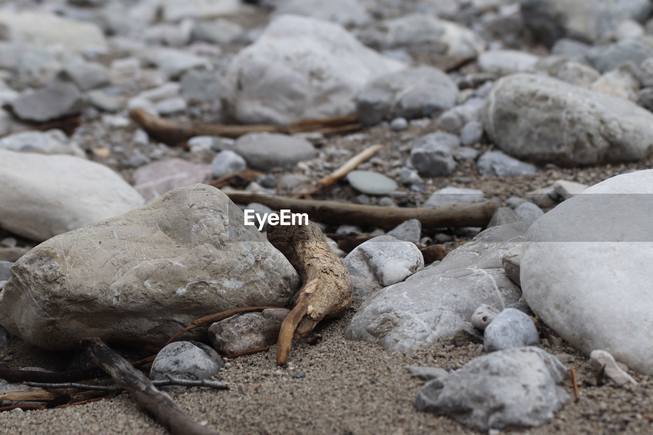 CLOSE-UP OF STONES ON SHORE