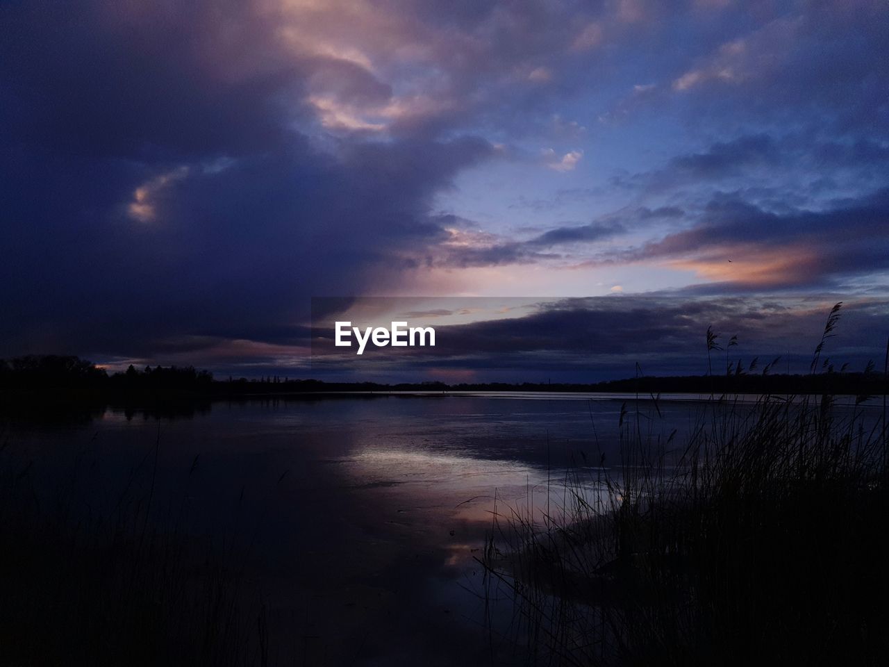 SCENIC VIEW OF LAKE AGAINST SKY AT DUSK