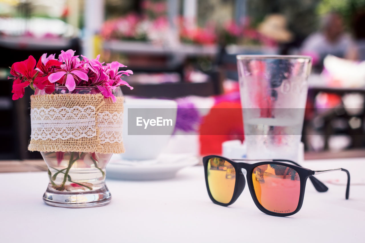 Sunglasses with flowers on table