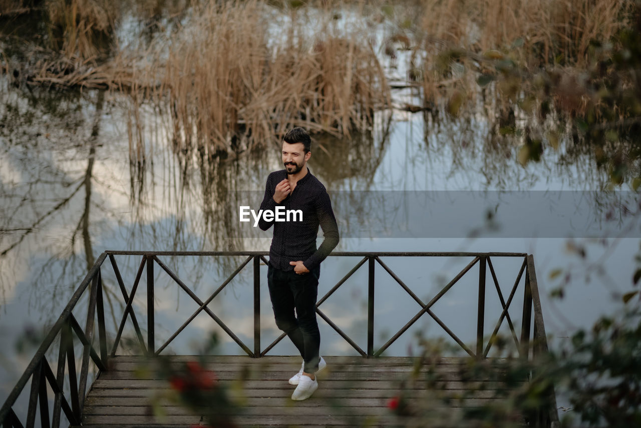 High angle view of man standing on pier over lake