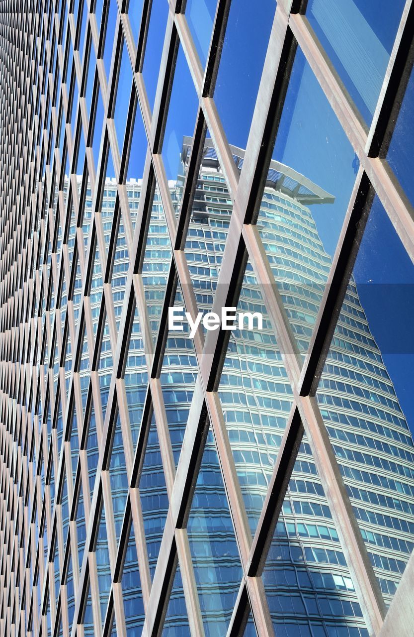 Low angle view of modern building against blue sky