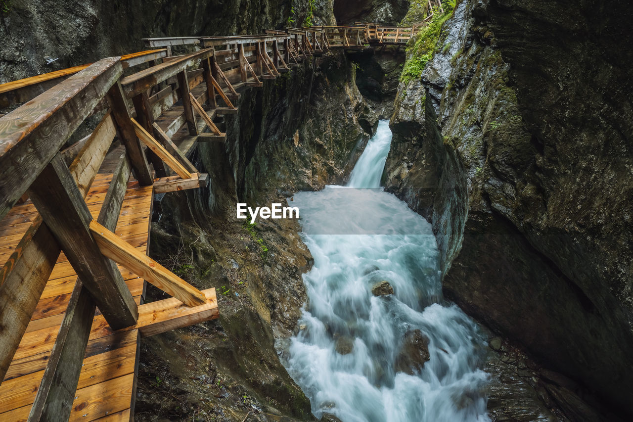 WATER FLOWING THROUGH ROCKS ON BRIDGE OVER ROCK