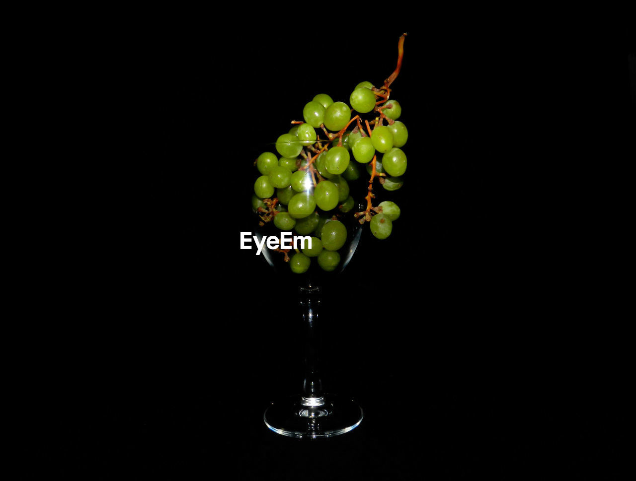 Close-up of grapes on table against black background