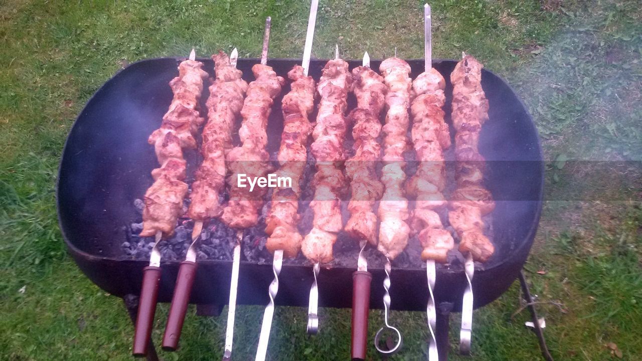 High angle view of meat smoking on barbecue grill