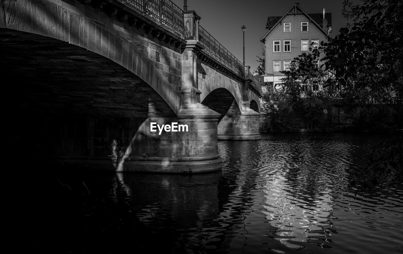 Bridge over river by buildings