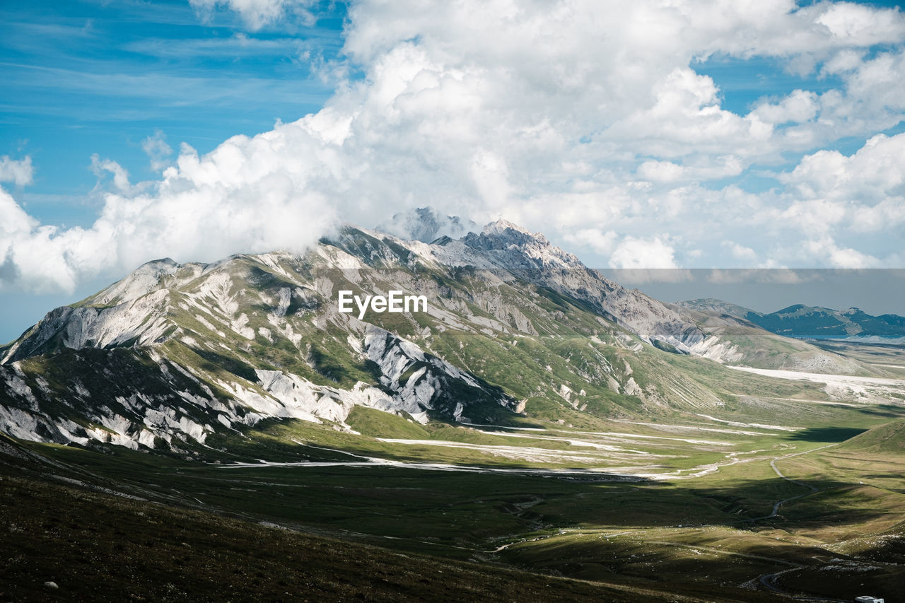 Scenic view of mountain against clouds and sky