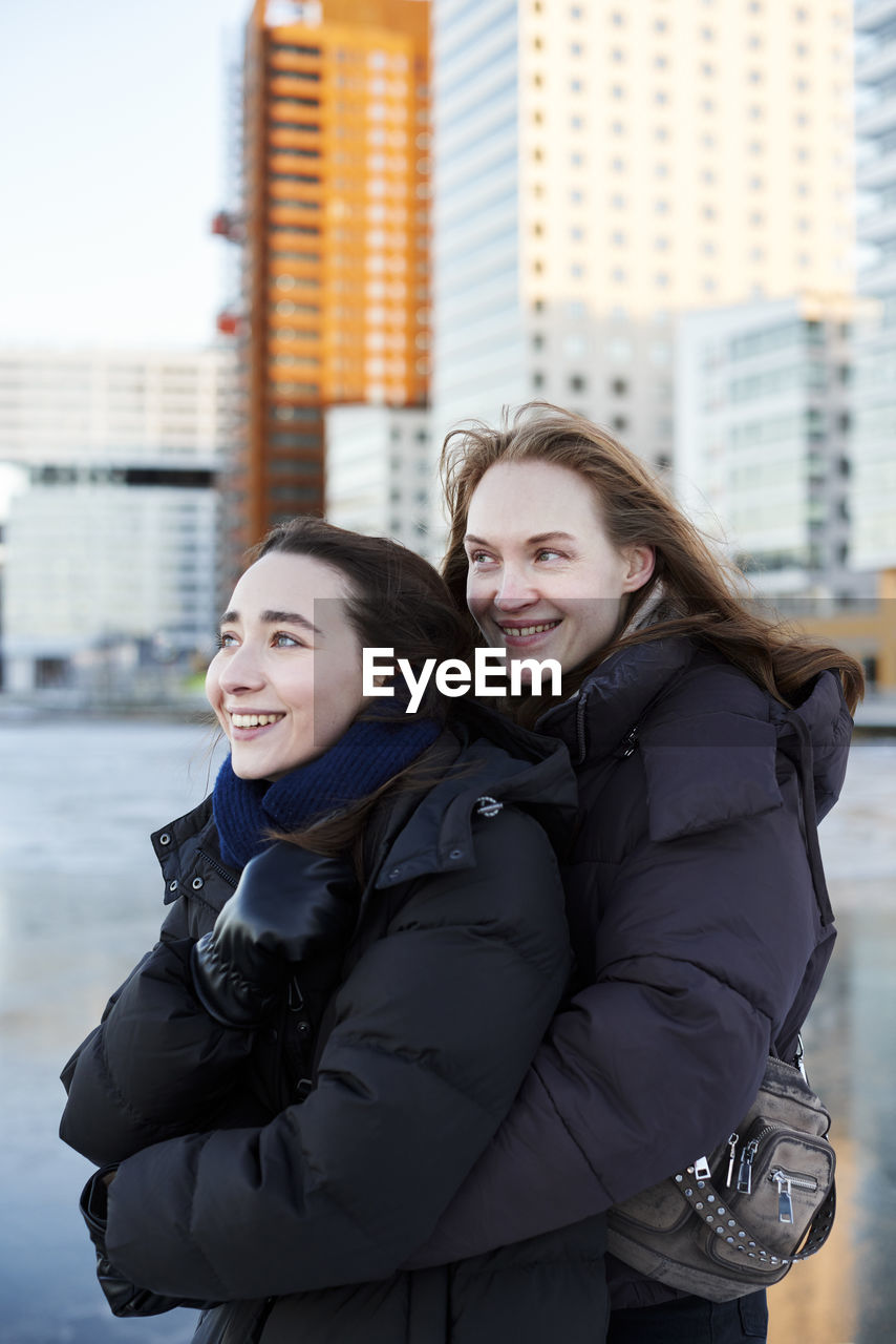 Smiling female couple in modern neighborhood