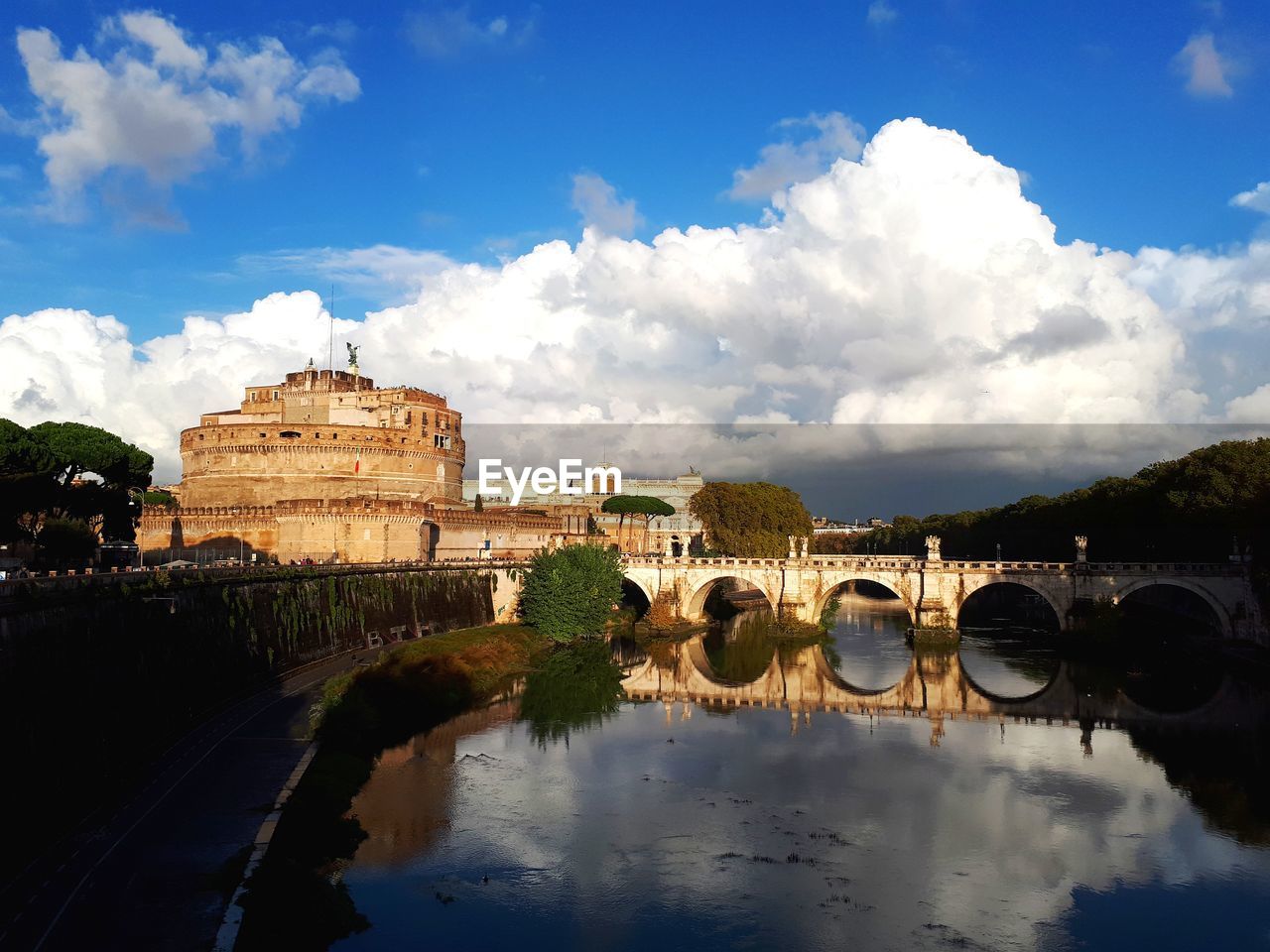 Arch bridge over tiber river by sant'angelo castle against sky in rome