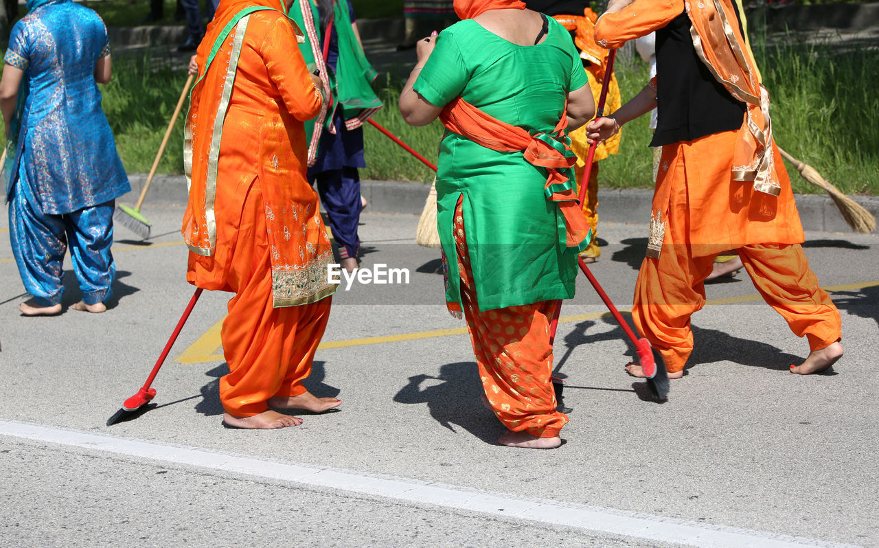 REAR VIEW OF PEOPLE WALKING ON ROAD