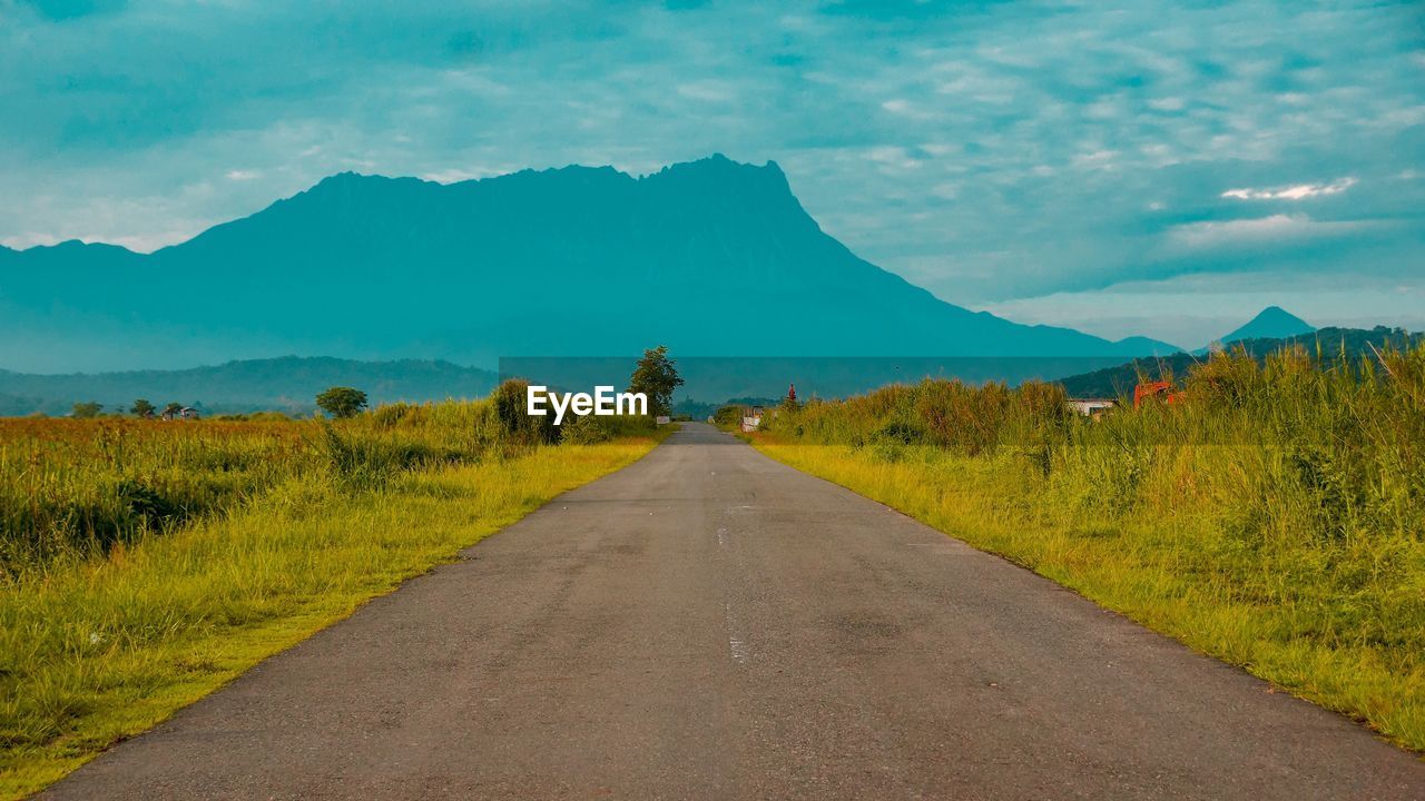 ROAD LEADING TOWARDS MOUNTAIN AGAINST SKY