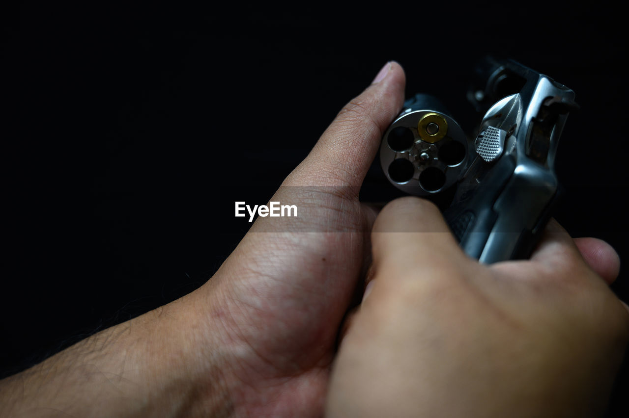 CLOSE-UP OF HUMAN HAND HOLDING BLACK BACKGROUND