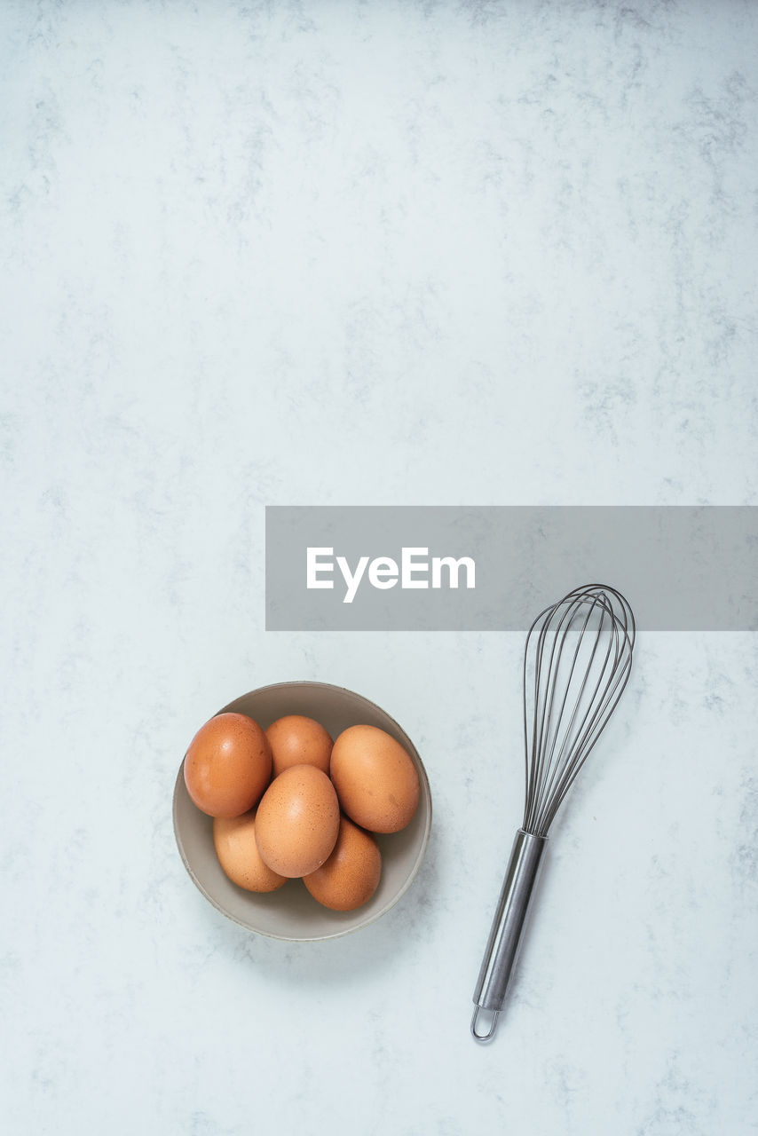 Some eggs and a beater on a cooktop