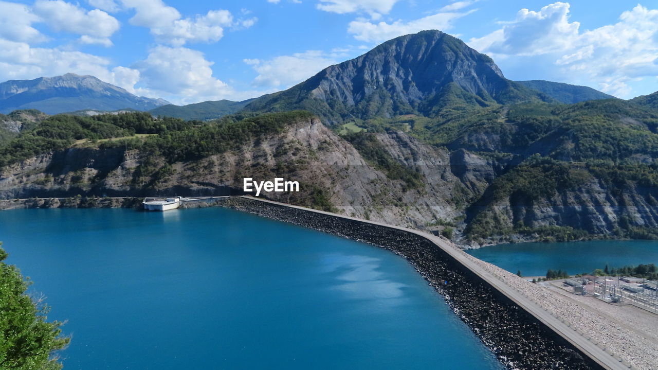 Scenic view of lake by mountains against sky