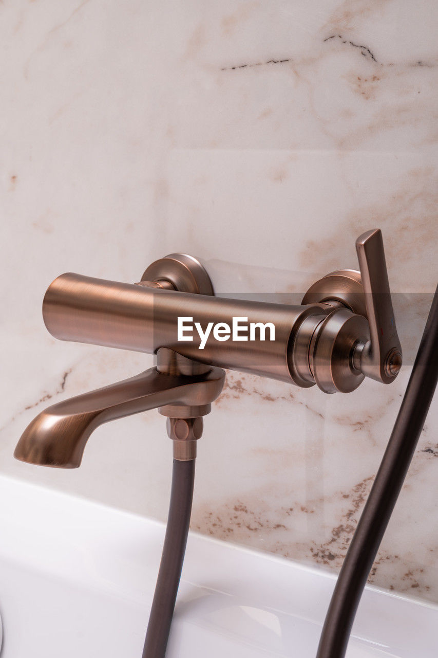 Close up of a copper bathtub tap, a plumbing fixture in a bathroom