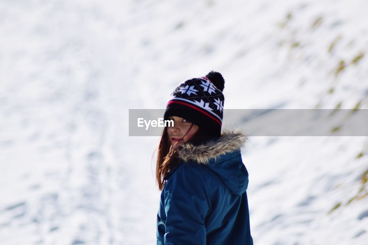 Rear view portrait of girl wearing blue warm clothing during winter