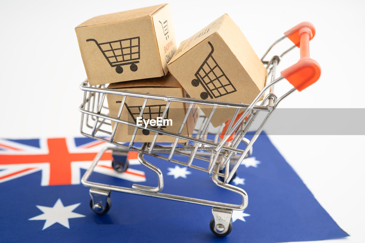 close-up of miniature shopping cart against white background