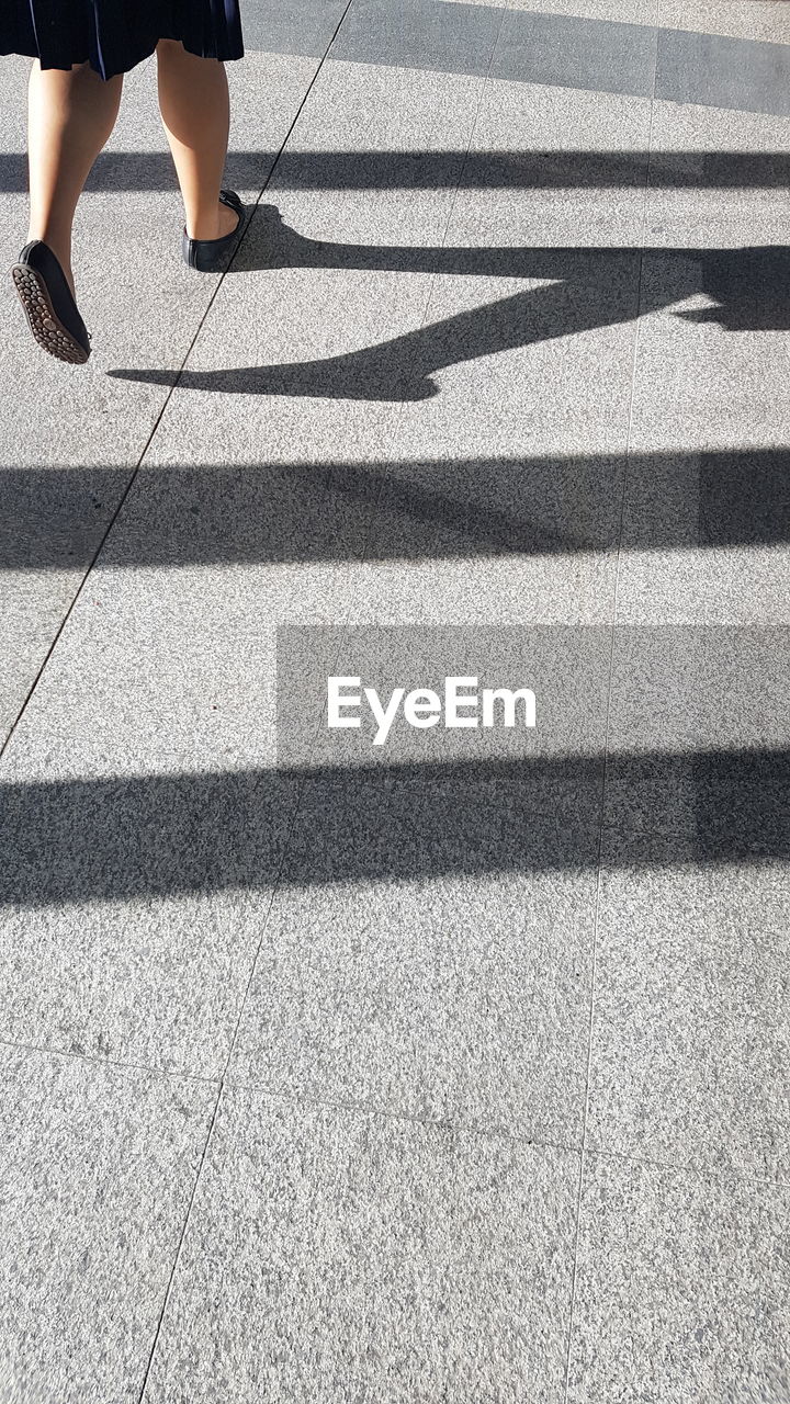 Low section of woman walking on tiled floor