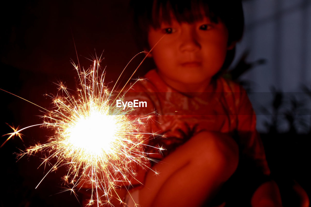 Low angle view of boy looking at fireworks