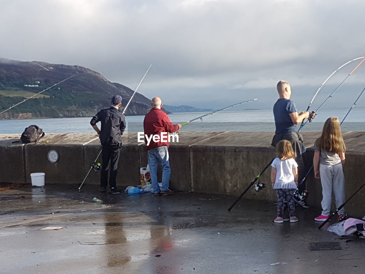 PEOPLE FISHING ON SEA AGAINST SKY