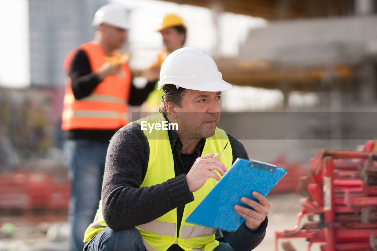 Manual workers wearing reflective clothing working on construction site