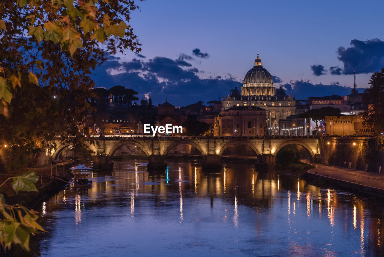 ILLUMINATED BRIDGE OVER RIVER IN CITY