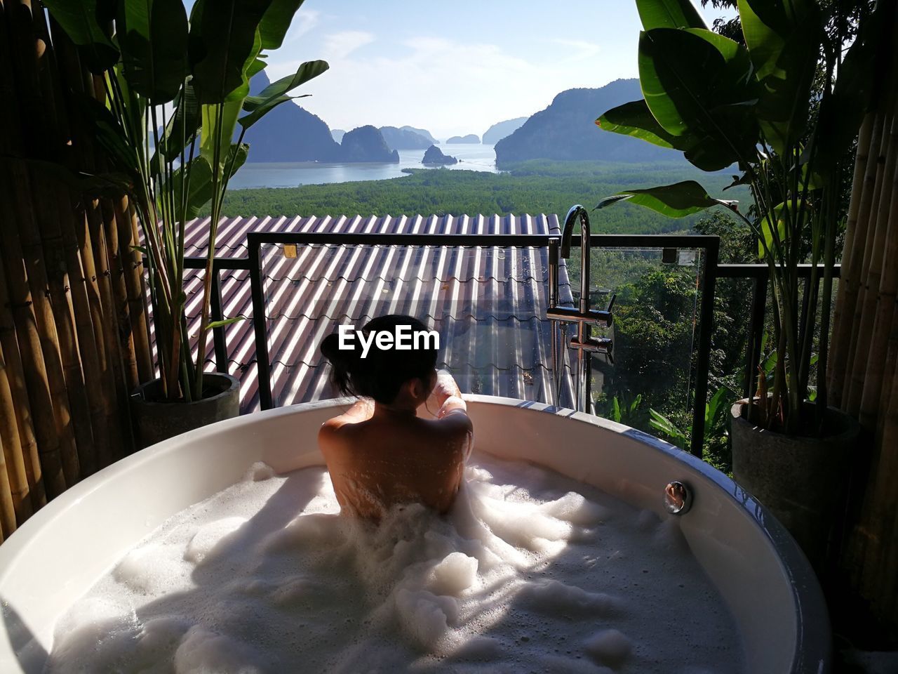 Rear view of woman relaxing in bathtub