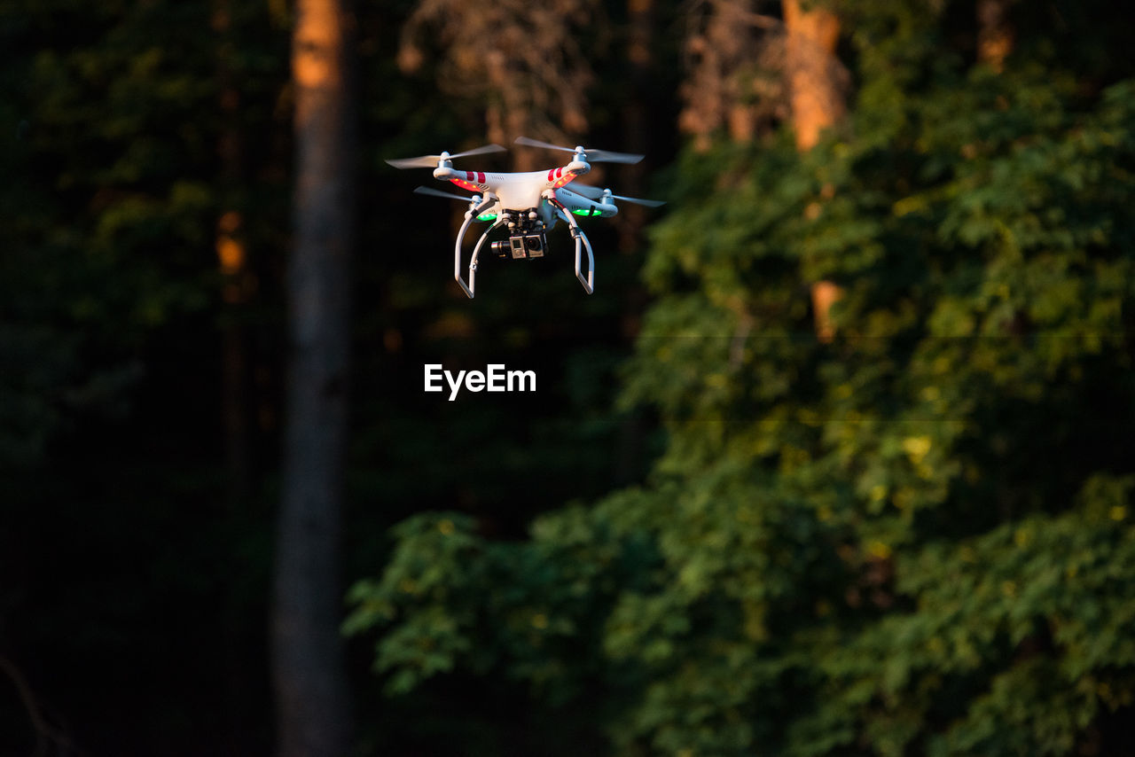 Close-up of drone against blurred trees