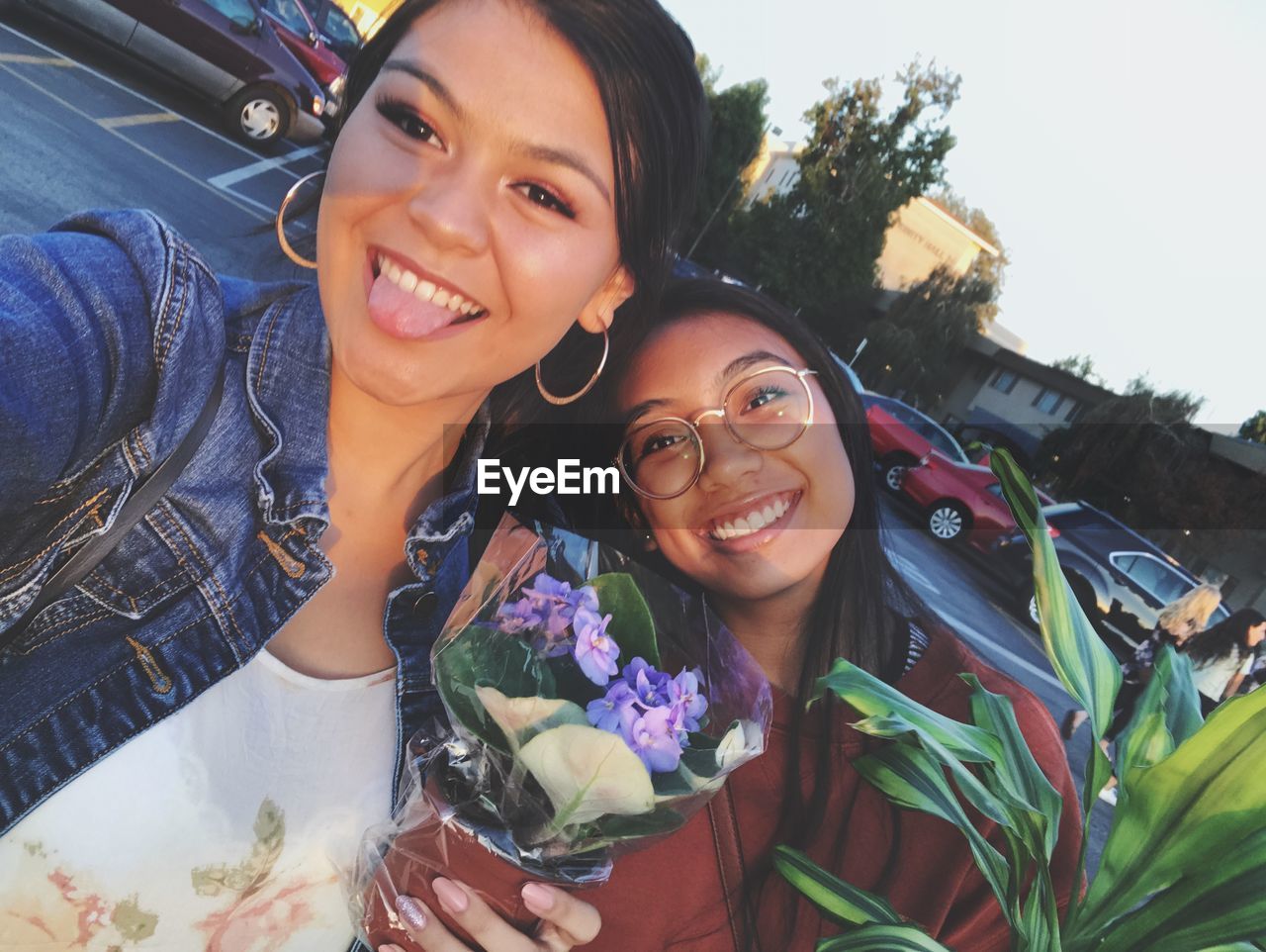 PORTRAIT OF A SMILING YOUNG WOMAN WITH FLOWER