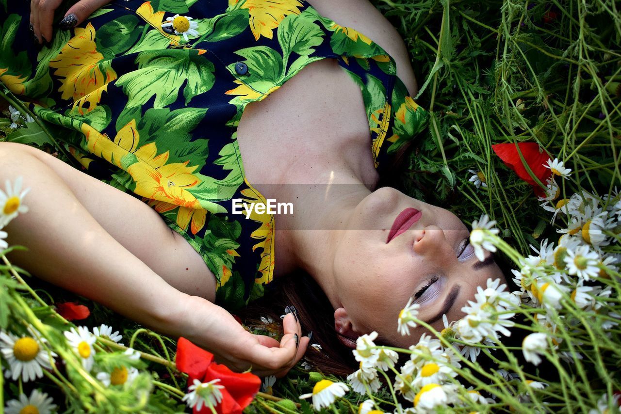 Close-up of woman lying on flower field