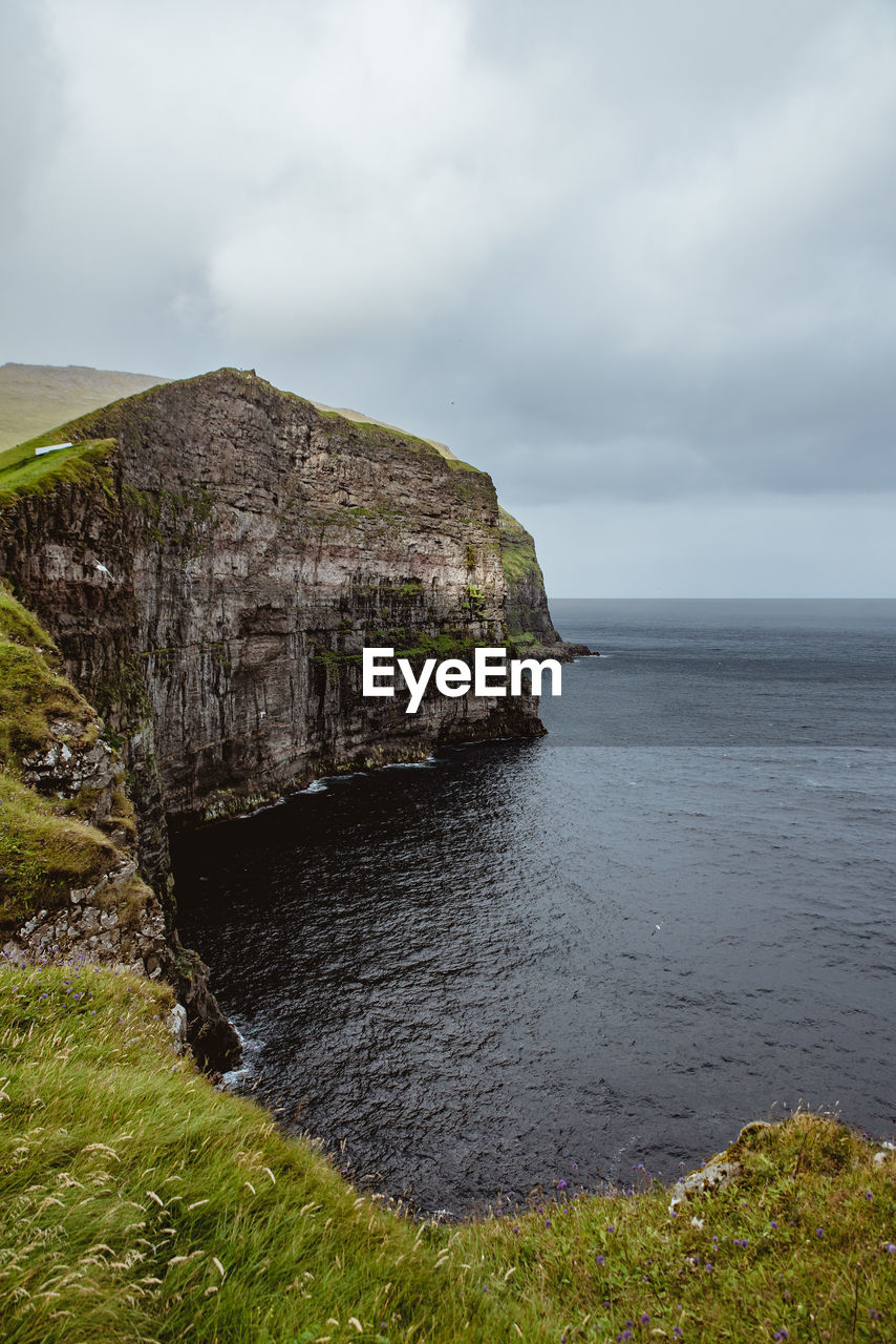 Rock formations by sea against sky