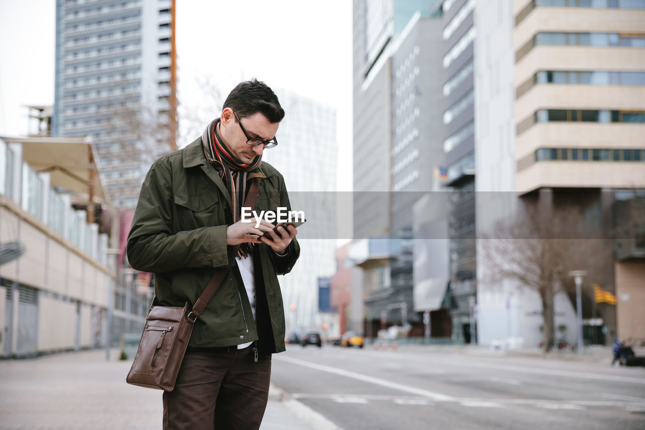 Man using mobile phone in city