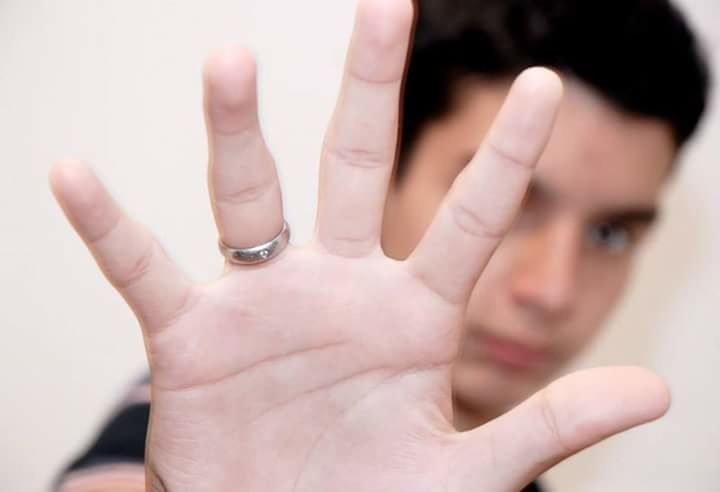 CROPPED IMAGE OF HAND HOLDING RING OVER WHITE BACKGROUND