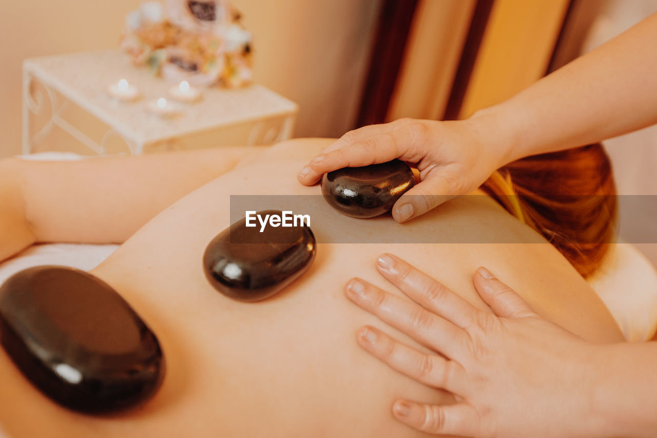 Woman doing hot stone therapy at spa