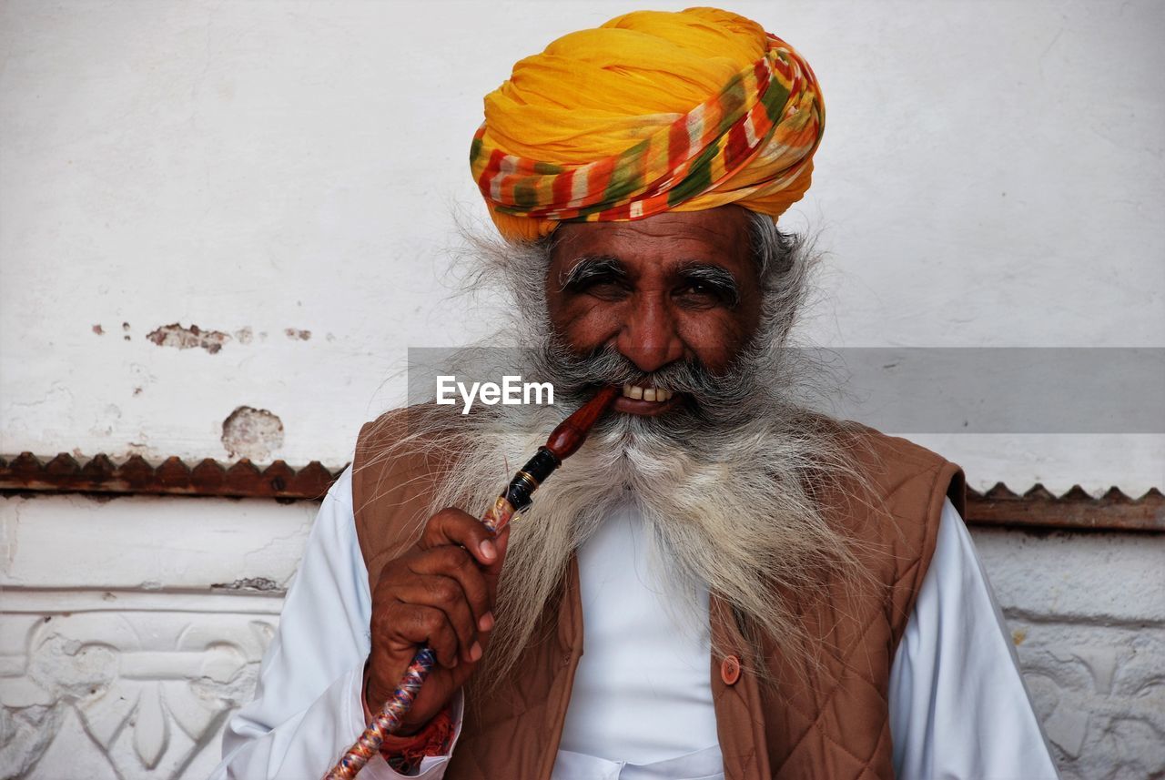 Midsection of man smoking pipe