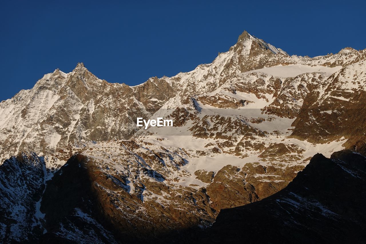 SNOWCAPPED MOUNTAINS AGAINST CLEAR SKY