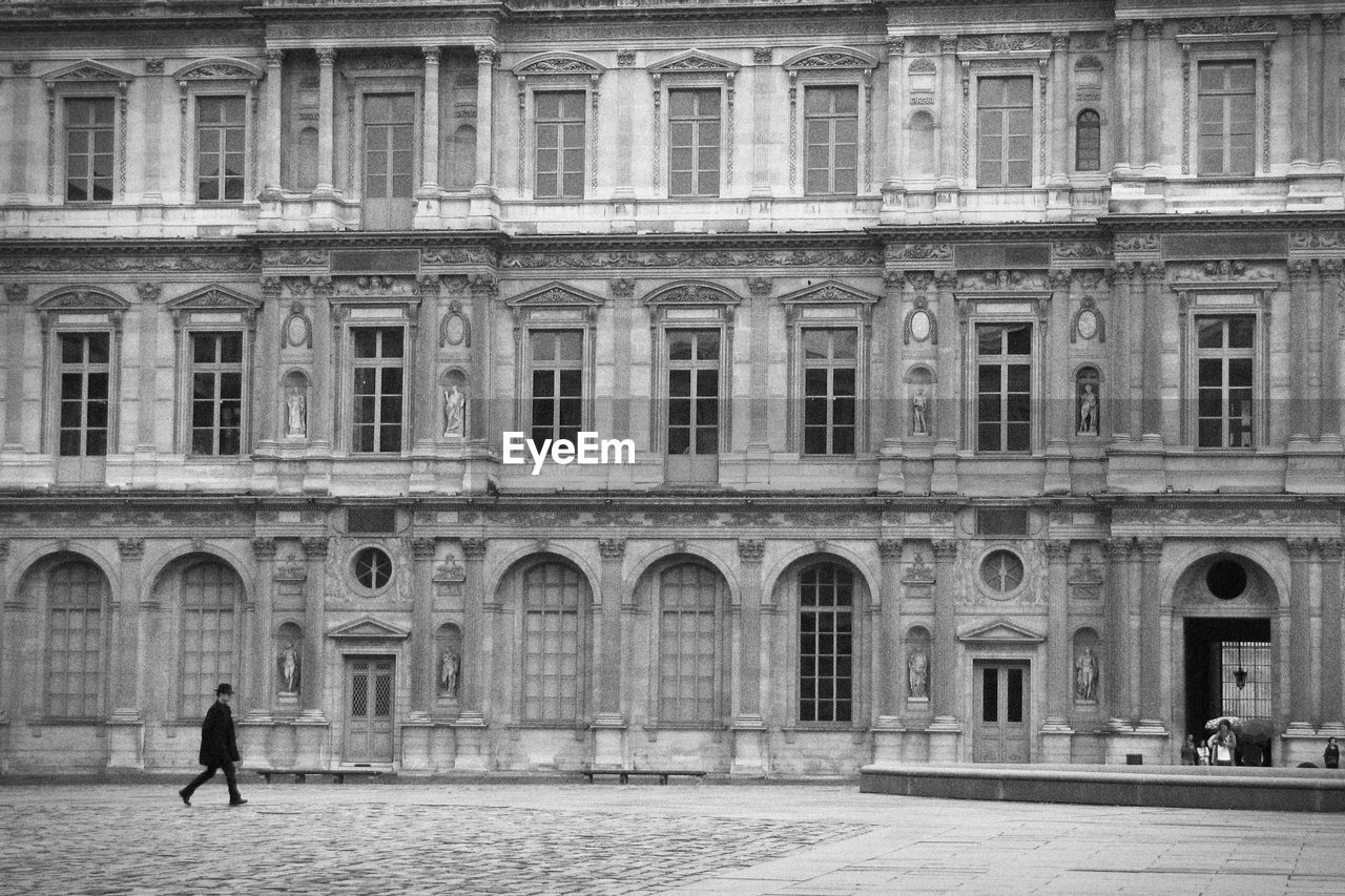 Man walking in front of building