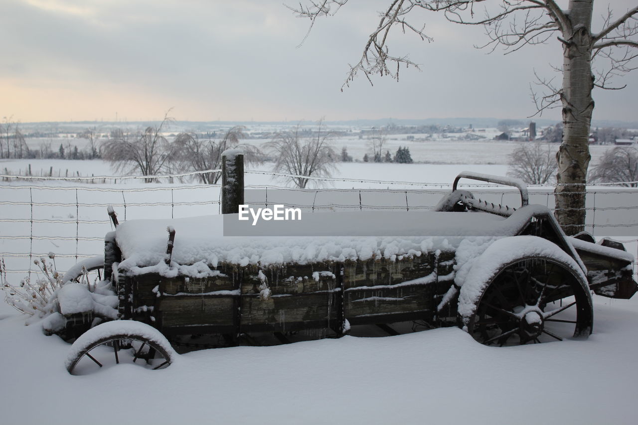 Side view of snow covered vintage vehicle