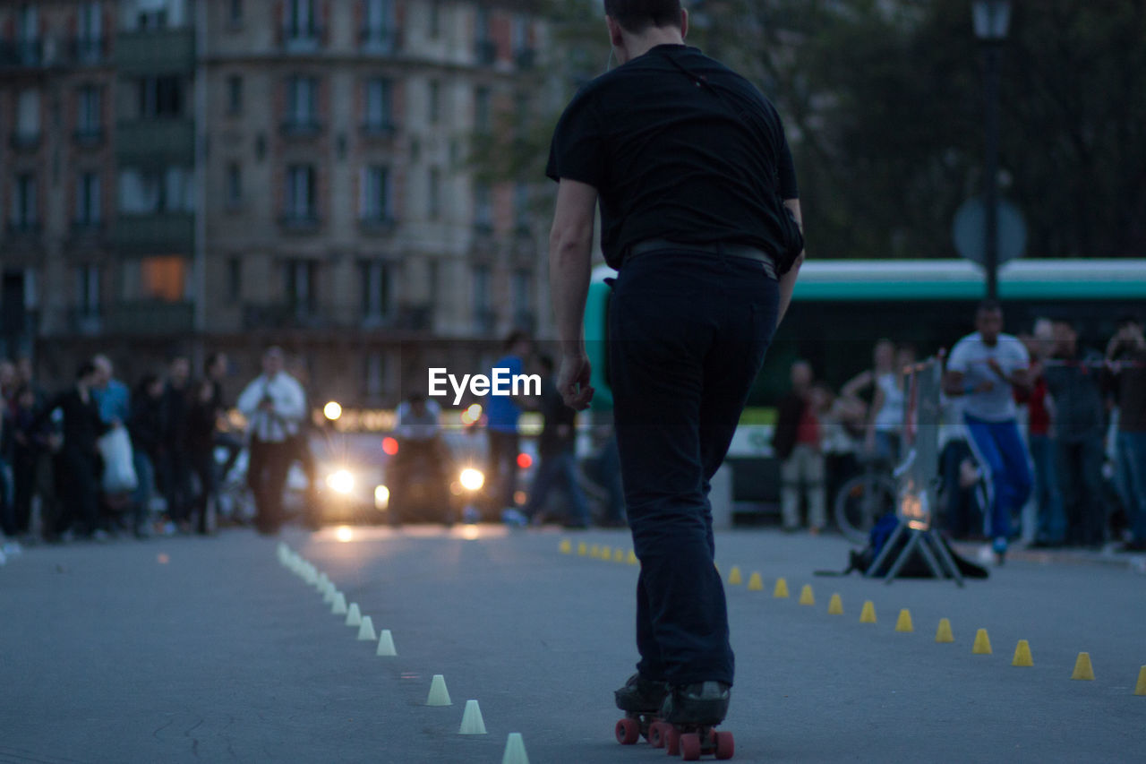 Rear view of man skating on road