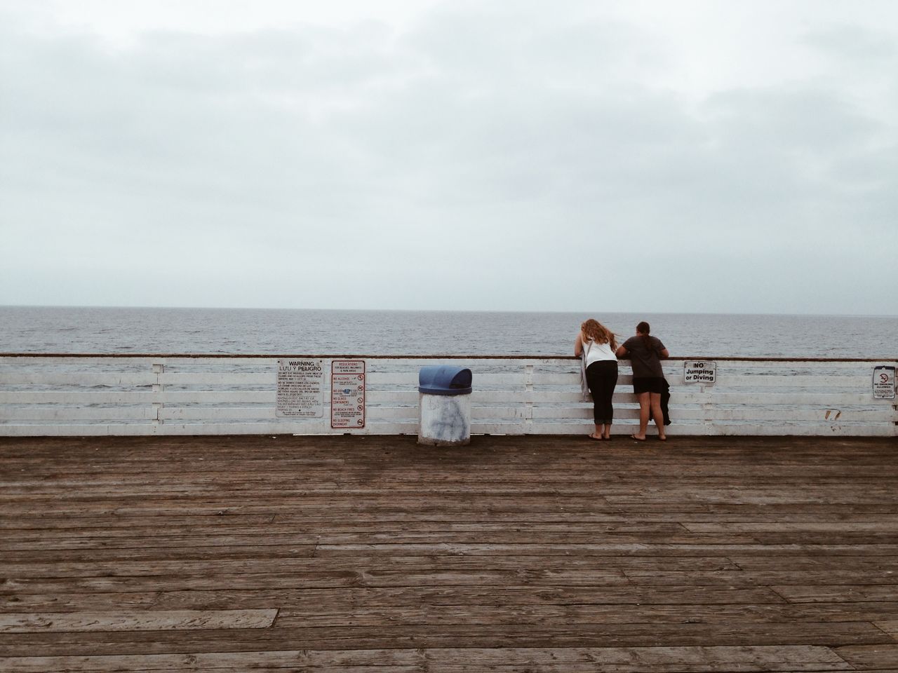 Rear view of women on promenade looking at sea