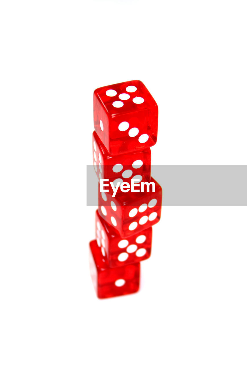 Close-up of red rolling dices over white background